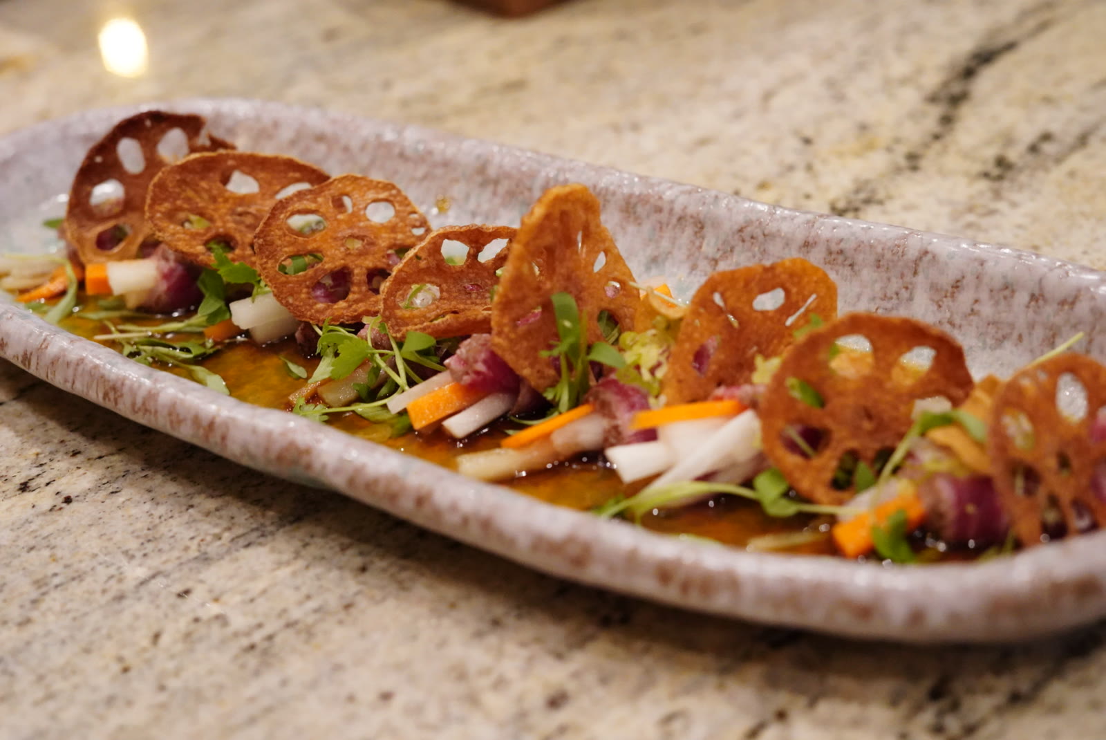 Seared peppercorn tuna tataki with lotus root chips and microgreens